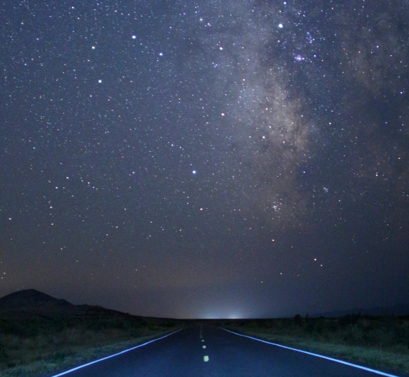 road at night under milky way in the sky